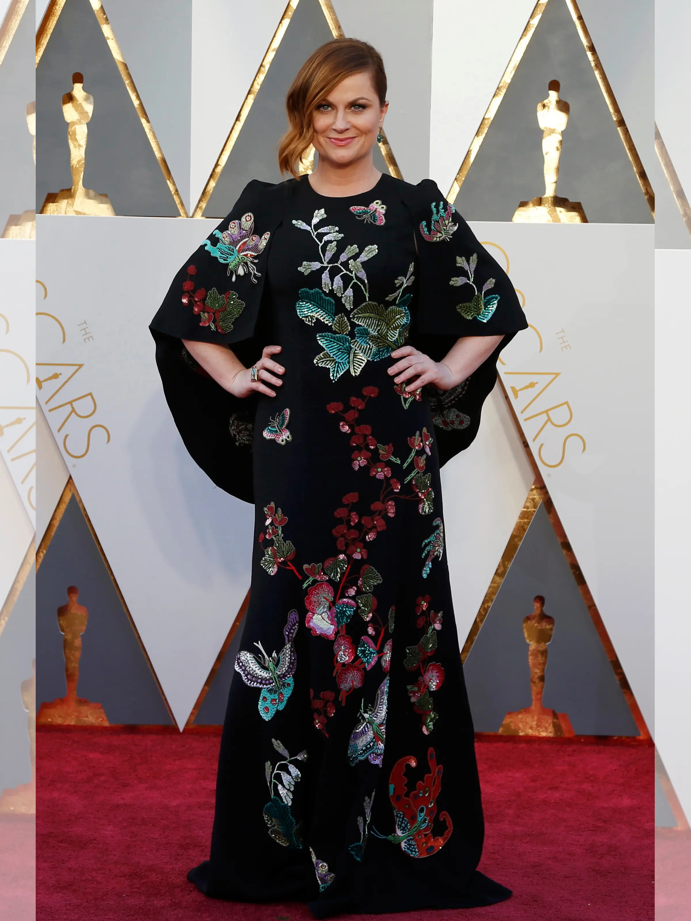 Aktris Amy Poehler mengenakan gaun hitam motif bunga dan kupu-kupu berjubahnya ketika berpose di red carpet Piala Oscar 2016 di Hollywood, California, Minggu (28/2). (REUTERS/ Lucy Nicholson)