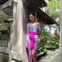 Laksmi Shari terlihat cantik dengan kebaya Bali berpayet berwawrna ungu kebiruan, dipadunya dnegan kain bermotif batik berwarna ungu dengan detail slit, dan selendang ungu muda yang diikatkannya di bagian pinggang. Foto: Instagram.