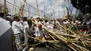 Peserta menyusun kayu untuk membentuk puncak kerucut saat ritual Mekotek di Bali (11/11). Ritual ini dimainkan secara bersama-sama untuk merayakan kemenangan dharma (kebaikan) melawan adharma (kejahatan). (AP Photo/Firdia Lisnawati)