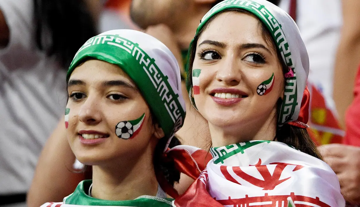 Dua orang Suporter Iran saat menyaksikan laga melawan Portugal pada laga Piala Dunia di Stadion Mordovia, Rusia, Senin (25/6/2018). Iran bermain imbang 1-1 dengan Portugal. (AFP/Filippo Monteforte)