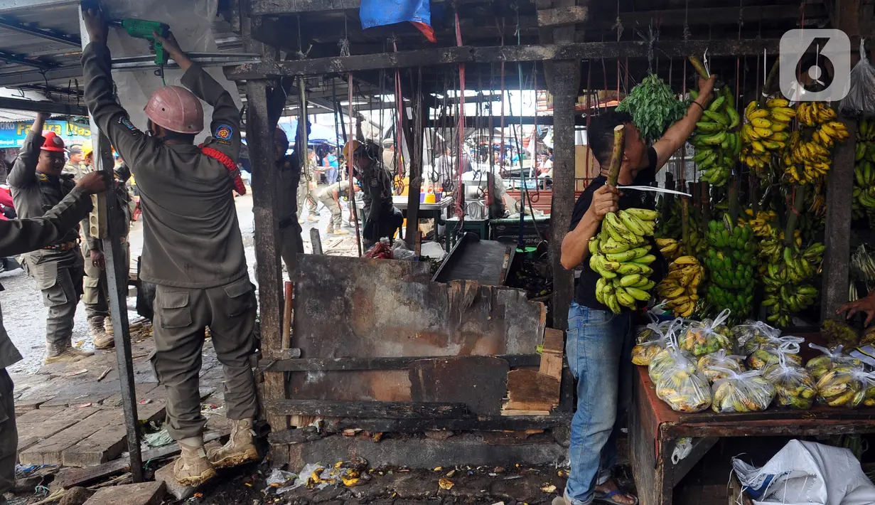 Petugas Satuan Polisi Pamong Praja (Satpol PP) Kota Tangerang Selatan membongkar lapak pedagang kaki lima (PKL) di luar area Pasar Ciputat, Tangerang Selatan, Banten, Selasa (14/2/2023). Penertiban ini ditujukan untuk puluhan lapak PKL di sekitar Jalan Aria Putera, Jalan H. Usman, Jalan Bancet, dan kawasan Polikarbonat karena keberadaannya mengganggu ketertiban umum di antaranya kemacetan lalu lintas. (merdeka.com/Arie Basuki)