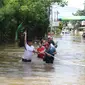 Warga berusaha melintasi banjir yang merendam perumahan Ciledug Indah, Tangerang, Banten, Kamis (2/1/2020). Memasuki hari kedua, kondisi perumahan tersebut masih tergenang banjir setinggi dada orang dewasa. (Liputan6.com/Angga Yuniar)