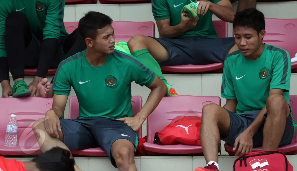 Penyerang timnas Indonesia U-23, Muchlis Hadi Ning Syaifulloh (kiri) berbincang dengan Evan Dimas usai berlatih di ITE College Center, Singapura, Minggu (31/5/2015). Mereka akan melakoni laga melawan Myanmar, 2 Juni. (Liputan6.com/Helmi Fithriansyah)