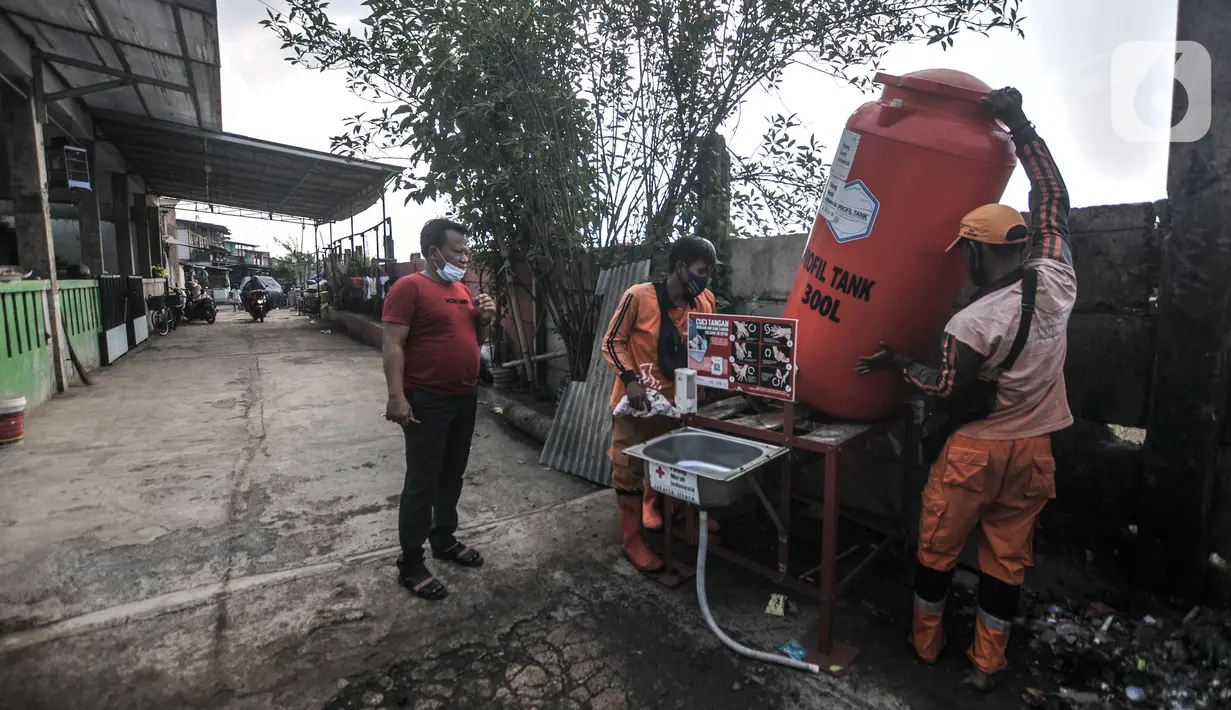 Petugas PPSU memasang fasilitas pencuci tangan di RT 01 RW 04, Kelurahan Semper Barat, Cilincing, Jakarta Utara, Kamis (3/6/2021). Sebanyak 22 orang di sana terkonfirmasi positif Covid-19 setelah mengikuti tahlilan warga yang meninggal akibat terpapar virus Corona. (merdeka.com/Iqbal S Nugroho)