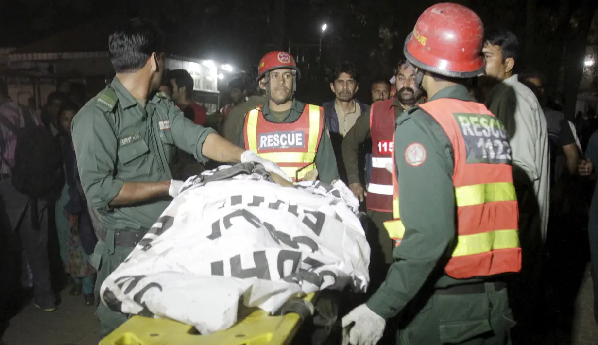 Petugas membawa korban tewas ledakan bom di area parkir taman Gulshan e Iqbal Park di Lahore, Pakistan, (27/3/2016). Ledakan terjadi saat banyak anak-anak dan orangtua sedang berada di area tersebut. (REUTERS / Mohsin Raza)