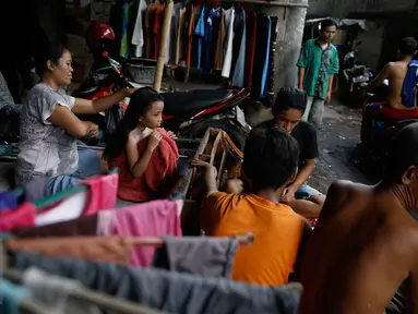 Seorang ibu menyisir rambut anaknya di pemukiman kolong jalan tol Ir Wiyoto Wiyono, Penjaringan, Jakarta, Minggu (13/3). Pemprov DKI berencana menggusur sebanyak delapan Rukun Warga (RW) yang menghuni kolong tol tersebut. (Liputan6.com/Faizal Fanani)