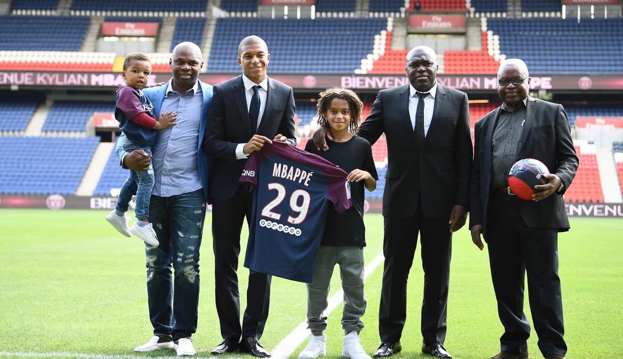 Penyerang baru PSG, Kylian Mbappe berfoto bersama keluarganya saat  sesi perkenalan di Parc des Princes stadium, Paris, (6/9/2017). Mbappe dipinjam PSG dari Monaco dengan opsi permanen sebesar 180 juta euro tahun berikutnya. (AFP/Franck Fife)