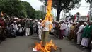 Dalam aksinya, massa melakukan pembakaran boneka di depan Balaikota, Jakarta, Senin (1/12/2014). (Liputan6.com/Faizal Fanani) 