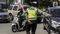 Polisi mengalihkan kendaraan saat pemberlakuan sistem ganjil genap di kawasan Jalan Sudirman, Jakarta, Kamis (12/8/2021). Kebijakan ini menggantikan penyekatan PPKM di delapan ruas jalan Ibu Kota. (Liputan6.com/Johan Tallo)