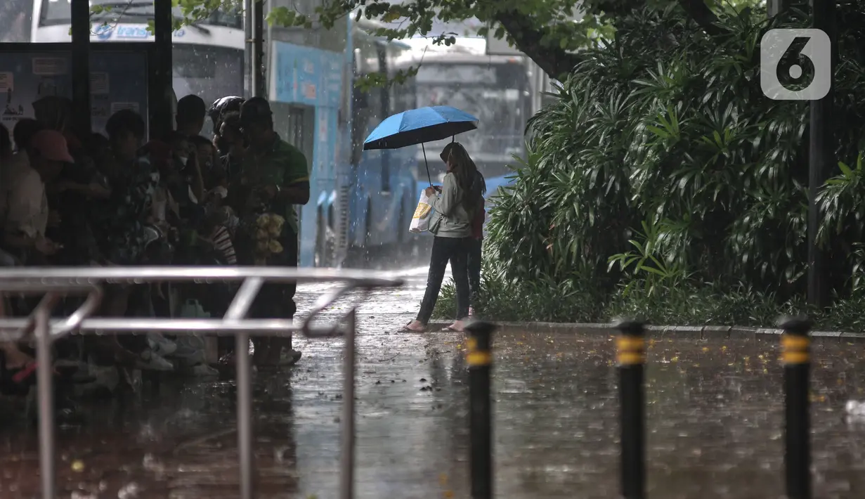 Warga menggunakan payung saat hujan mengguyur kawasan Monas, Jakarta Pusat, Kamis (5/1/2023). Warga diharapkan waspada serta mempersiapkan diri dengan perubahan cuaca yang akan terjadi selama satu pekan ke depan. (merdeka.com/Iqbal S Nugroho)