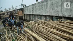 Anak-anak pesisir dan sukarelawan saat membersihkan sampah di Pemukiman Nelayan Manunggal, Cilincing, Jakarta Utara, Minggu (18/9/2022). Tumpukan sampah yang berserakan di kawasan pemukiman nelayan Manunggal, Cilincing menginisasi Kelas Jurnalis Cilik untuk membersihkan sampah dan mengedukasi kepada anak-anak pesisir serta masyarakat pentingnya menjaga kebersihan di lingkungan sekitar. (merdeka.com/Iqbal S. Nugroho)