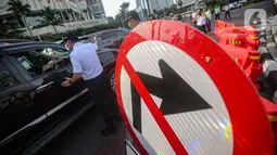 Petugas gabungan memberikan arahan kepada pengendara saat uji coba rekayasa lalu lintas di kawasan Bundaran HI, Jakarta Pusat, Senin sore (4/7/2022). Rekayasa lalu lintas di Bundaran HI merupakan salah satu upaya memperlancar arus lalin di Jenderal Sudirman Thamrin. (Liputan6.com/Faizal Fanani)