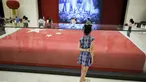 Seorang gadis melihat bendera nasional Tiongkok yang dikibarkan pada 1 Oktober 1949 di Lapangan Tiananmen di Museum Nasional China di Beijing (22/8/2019). Negara itu akan merayakan peringatan ke-70 berdirinya Pendirian Republik RakyatTiongkok pada tanggal 1 Oktober 2019. (AFP Photo/Wang Zhao)
