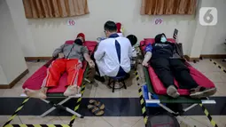 Petugas PMI mengambil darah pendonor sukarela di Jalan Kramat Raya, Jakarta, Kamis (30/4/2020). PMI menyatakan selama penerpan "physical distance" untuk menekan penyebaran COVID-19, jumlah pendonor sukarela berkisar 100 sampai 200 orang per hari atau turun 90 persen. (Liputan6.com/Faizal Fanani)