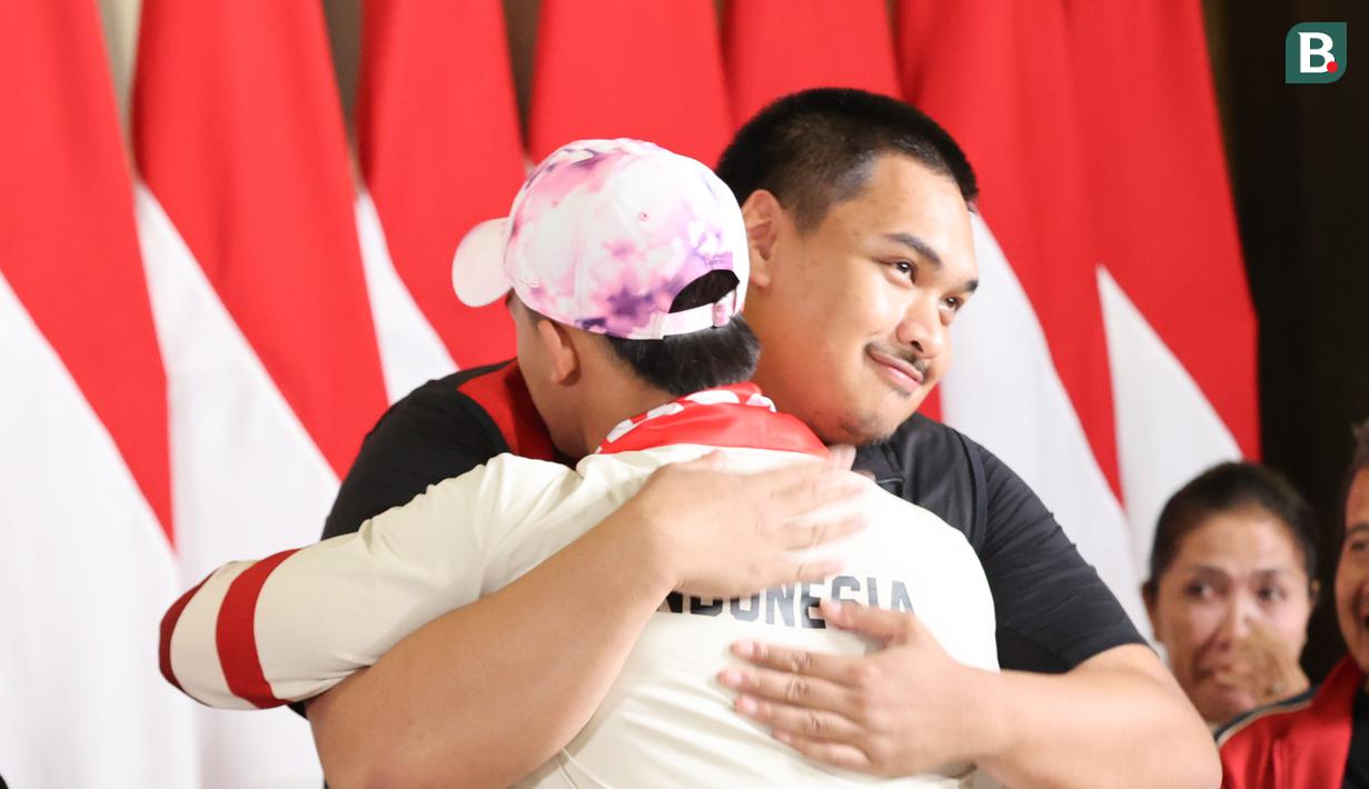 <p>Menteri Pemuda dan Olahraga Dito Ariotedjo memeluk peraih medali emas cang angkat besi nomor 73kg&nbsp;Rizki Juniansyah usai&nbsp;tiba di Bandara Internasional Soekarno-Hatta, Tangerang, Selasa (13/8/2024). (Abdul Aziz/Bola.com).</p>