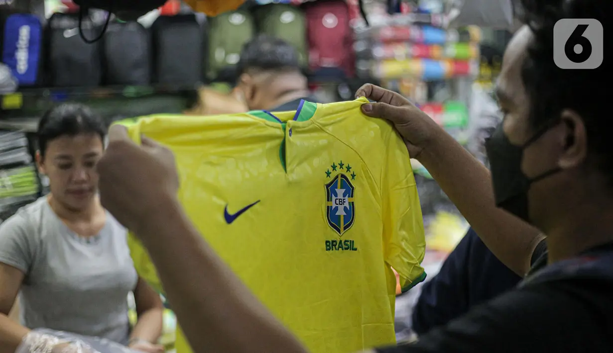 Pembeli melihat jersey Brasil tim peserta Piala Dunia 2022 Qatar di salah satu kios di Blok B Pasar Tanah Abang, Jakarta, Jumat (18/11/2022). Jersey sejumlah tim nasional favorit peserta Piala Dunia 2022 Qatar seperti Belanda, Brasil, Jerman, serta Argentina banyak diburu pembeli. (Liputan6.com/Faizal Fanani)