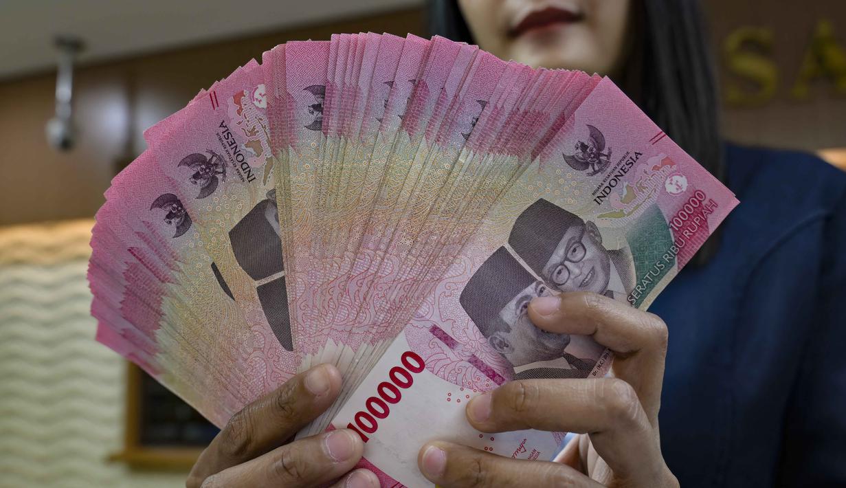 Ini menjadi titik pelemahan terdalam sepanjang sejarah perdagangan rupiah. Pelemahan ini lebih dalam jika dibandingkan titik terendah saat Krisis Moneter 1998 (Rp16.650) dan masa pandemi Covid-19 (Rp16.575). Tampak dalam foto, seorang menghitung uang kertas Rupiah di salah satu kantor penukaran uang, Jakarta, Selasa 12 Mei 2026, di tengah depresiasi Rupiah terhadap Dolar Amerika Serikat. (BAY ISMOYO/AFP)