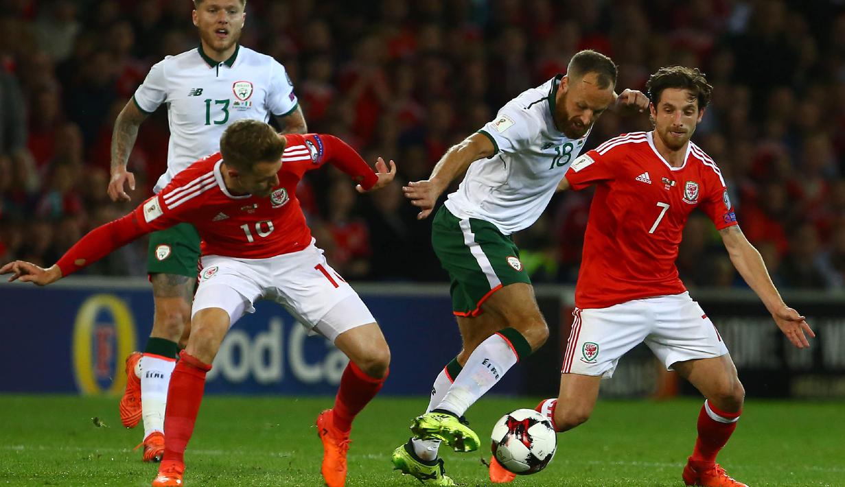 Gelandang Irlandia, David Meyler, berusaha melewati gelandang Wales, Aaron Ramsey, pada laga kualifikasi Piala Dunia 2018 di Stadion Cardiff City, Cardiff, Senin (9/10/2017). Wales kalah 0-1 dari Irlandia. (AFP/Geoff Caddick)