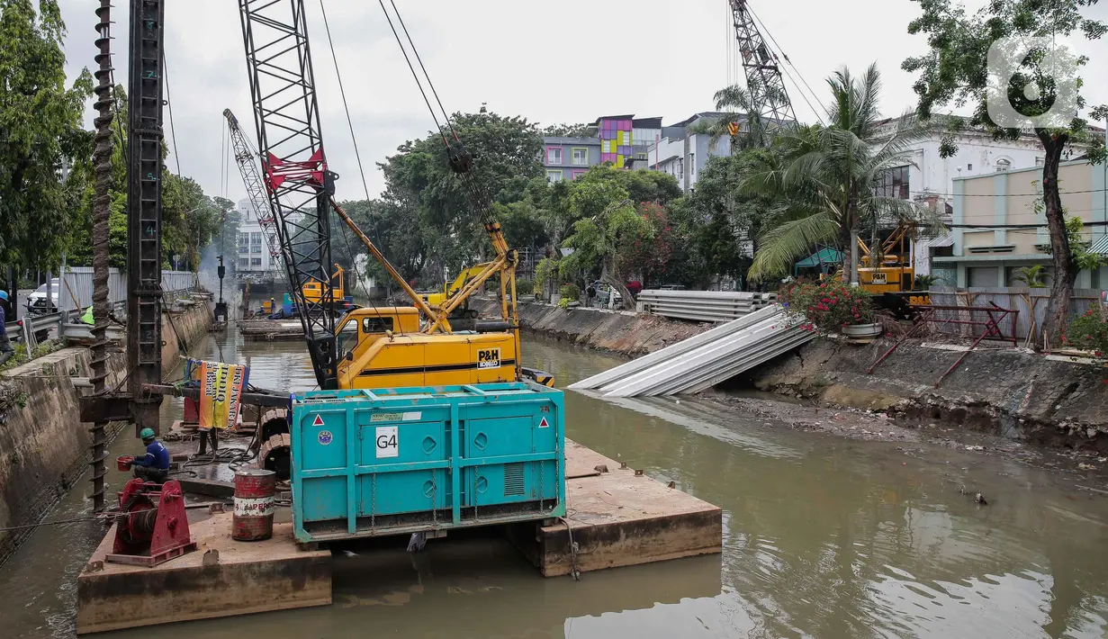 Pekerja menyelesaikan pemasangan dinding turap di kali pasar baru, Jakarta, Rabu (9/3/2022). Dinas Sumber Daya Air DKI Jakarta melakukan pemasangan turap bertujuan untuk mengantisipasi banjir serta tanah ambles di pinggir sungai. (Liputan6.com/Faizal Fanani)