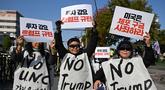 Para demonstran Korea Selatan yang mengenakan spanduk bertuliskan "Tolak Trump" memegang plakat selama demonstrasi yang mengecam tekanan Presiden AS Donald Trump untuk meningkatkan investasi Korea Selatan di AS, di Gyeongju pada 29 Oktober 2025, menjelang KTT Kerja Sama Ekonomi Asia-Pasifik (APEC). (Jung Yeon-je/AFP)