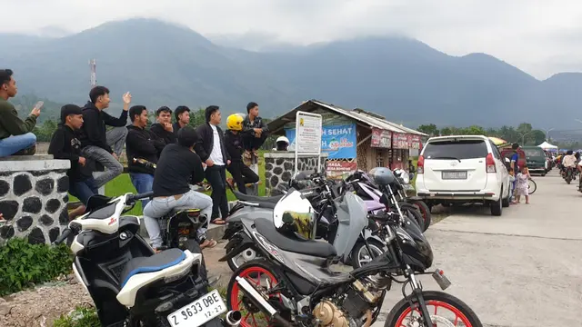 Berlatar view indah Gunung Guntur Garut, beberapa kaula muda Garut terlihat nongkrong sambil ngabuburit di jalan Letjen (Purn) Ibrahim Adjie Garut. (Liputan6.com/Jayadi Supriadin)
