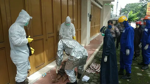 Petugas ber-APD lengkap mengevakuasi jenazah tukang becak yang meninggal dunia di emper toko. (Foto: Dok. Tagana Banyumas/Liputan6.com/Ridlo)