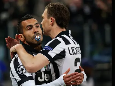 Penyerang Juventus, Carlos Tevez (kiri) memeluk Stephan Lichtsteiner usai mencetak gol saat laga melawan Borussia Dortmund di 16 besar Liga Champions (leg 1) di Stadion Juventus, Turin, Italia, (24/2/2015). (AFP PHOTO/GIUSEPPE CACACE)