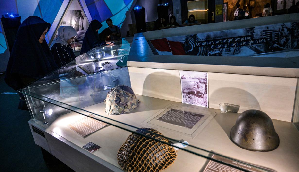 Untuk tahun ini ada empat museum yang dilibatkan, yakni Museum Naskah Proklamasi Jakarta, Museum Pers Nasional Solo, Museum Islam Nusantara KH Hasyim Asy’ari Jombang, serta Museum Tugu Pahlawan Surabaya. Tampak dalam foto, pengunjung mengamati peralatan militer yang disita Indonesia dari pasukan Jepang, India Britania, dan Belanda di tengah Pertempuran Surabaya, yang terjadi pada bulan November 1945 antara pejuang Indonesia melawan pasukan Sekutu Inggris dan NICA untuk menegakkan kembali kekuasaan kolonial Belanda setelah berakhirnya Perang Dunia II, dalam acara 'Malam di Museum 2025' di Museum 10 November, Surabaya, Jawa Timur, Sabtu 29 November 2025. (Juni KRISWANTO/AFP)