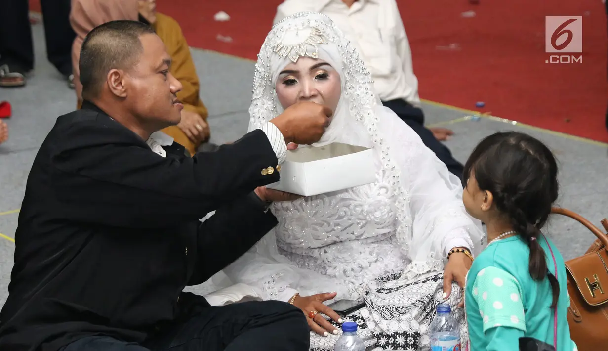 Pasangan nikah massal meluapkan kebahagiaan usai ijab kabul di jalan MH Thamrin, Jakarta, Senin (31/12). 557 pasangan mengikuti nikah massal dan isbat nikah pada malam pergantian tahun 2018-2019. (Liputan6.com/Helmi Fithriansyah)