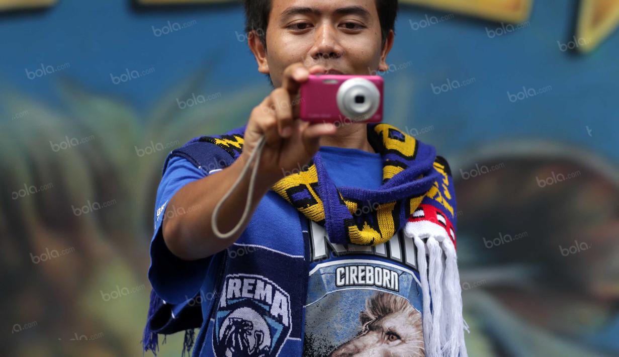 Suporter Aremania memanfaatkan waktu luang dengan berfoto didepan kantor PSSI sebelum  mendukung timnya berlaga pada final Torabika Bhayangkara Cup 2016 di Stadion Utama Gelora Bung Karno, Jakarta, Minggu (3/4/2016). (Bola.com/Nicklas Hanoatubun)