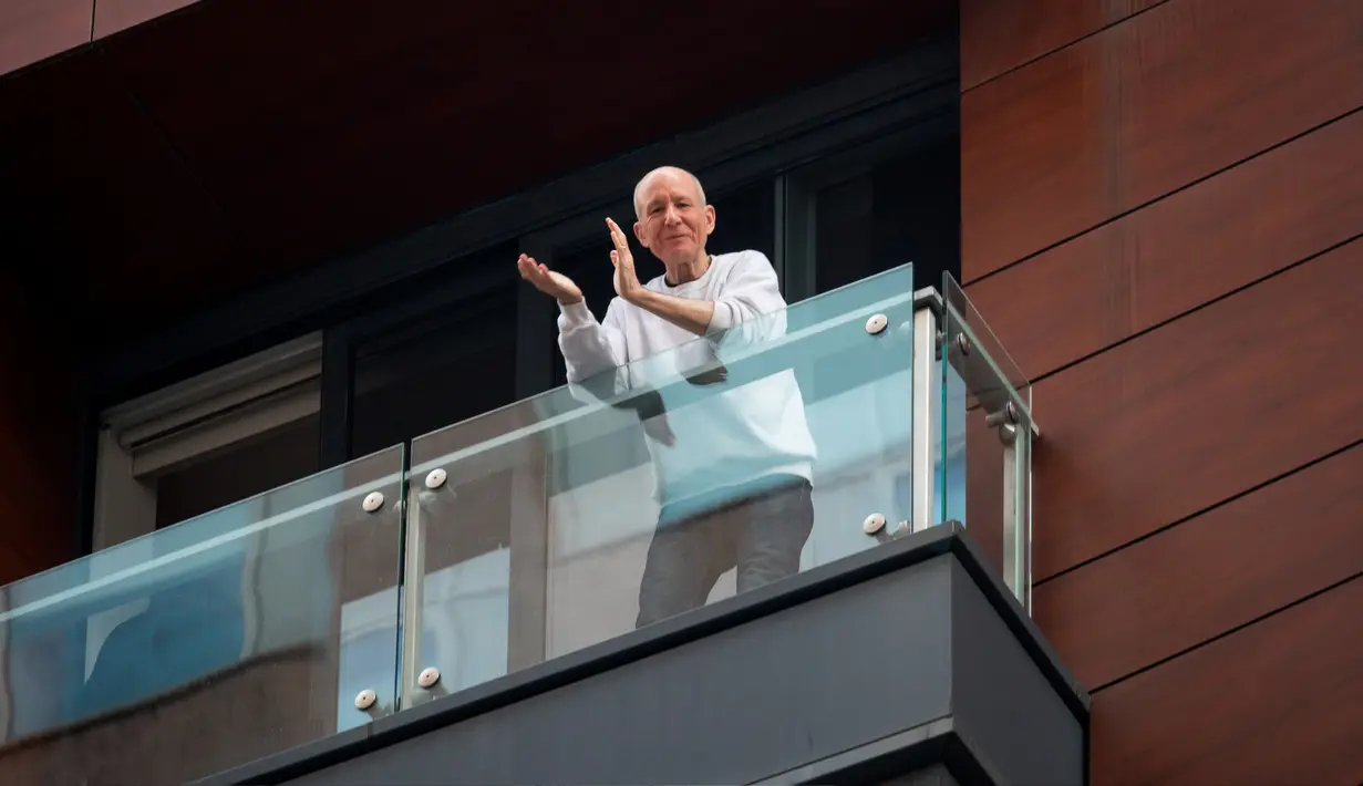 Seorang pria bertepuk tangan di balkon kediamannya di New York, AS (16/4/2020). Setiap malam pukul 19.00 waktu setempat, warga bertepuk tangan menyemangati pekerja esensial mendukung dan mengapresiasi selama pandemi COVID-19. (Xinhua/Michael Nagle)