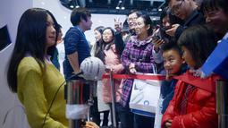 Pengunjung melihat robot humanoid (kiri) selama Konferensi Robot Dunia di Beijing pada 24 November 2015. Wajah dari robot ini sangat mirip dengan manusia bahkan bila disempurnakan makan kita akan susah membedakannya. (AFP PHOTO/WANG Zhao)