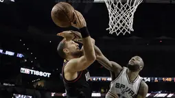Pemain Houston Rockets, Ryan Anderson (kiri) mencoba melakukan tembakan saat diadang pemain Spurs, Jonathon Simmons pada gim kelima NBA basketball playoff series di San Antonio, (9/5/2017). Spurs menang 110-107. (AP/Eric Gay)