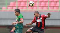 Duel udara pemain Persipura Jayapura, Yustinus Pae (kanan) dan pemain PS TNI, Manahati Lestusen  pada lanjutan Liga 1 2017 di Stadion Patriot, Bekasi (4/11/2017). PS TNI menang 2-1. (Bola.com/Nick Hanoatubun)