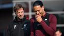 Pelatih Liverpool, Jurgen Klopp, berbincang dengan Virgil van Dijk saat sesi latihan jelang laga Liga Champions di Melwood, Liverpool, Senin (8/4). Liverpool akan berhadapna dengan Porto. (AFP/Paul Ellis)