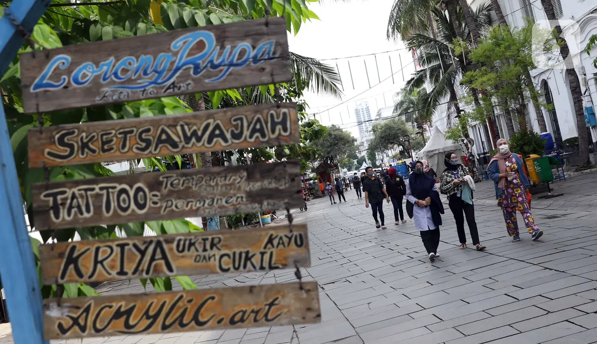 Pengunjung menggunakan masker memasuki kawasan Kota Tua Jakarta, Kamis (29/10/2020). Libur panjang di masa pemberlakuan PSBB transisi Jakarta dimanfaatkan warga untuk mengunjungi lokasi-lokasi wiisata. (Liputan6.com/Helmi Fithriansyah)