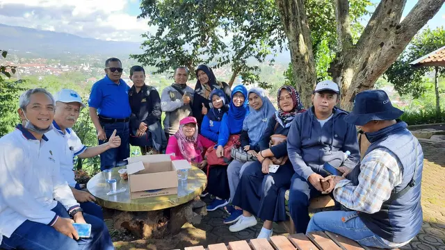 Keluarga alumni Institut Pertanian Bogor (IPB) nampak menikmati indahnya pemandangan di atas puncak Kebun Naga Poernama, Bayongbong, Garut, Jawa Barat.