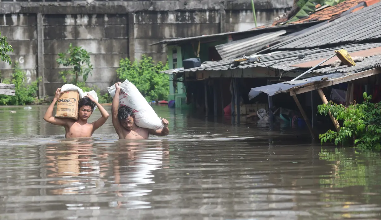 Warga menyelamatkan sagu miliknya saat banjir menggenangi area Kampung Cantiga, Petir, Cipondoh, Kota Tangerang, Banten, Selasa (8/7/2025). (merdeka.com/Arie Basuki)