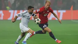 Pemain LOSC Lille, Mitchel Bakker (kanan) berebut bola dengan pemain Real Madrid, Dani Carvajal pada laga Liga Champions yang berlangsung di Pierre-Mauroy Stadium, Villeneuve d'Ascq, Prancis, 2 October 2024. (AFP/Francois Lo Presti)