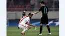 Mesut Ozil (kanan), menghibur pemain Olympiacos, Dimitris Siovas, setelah bertanding dalam lanjutan Grup F Liga Champions yang dimenangi Arsenal di Stadion Georgios Karaiskakis, Piraeus, Yunani, (9/12/2015). (AFP/Angelos Tzortzinis)