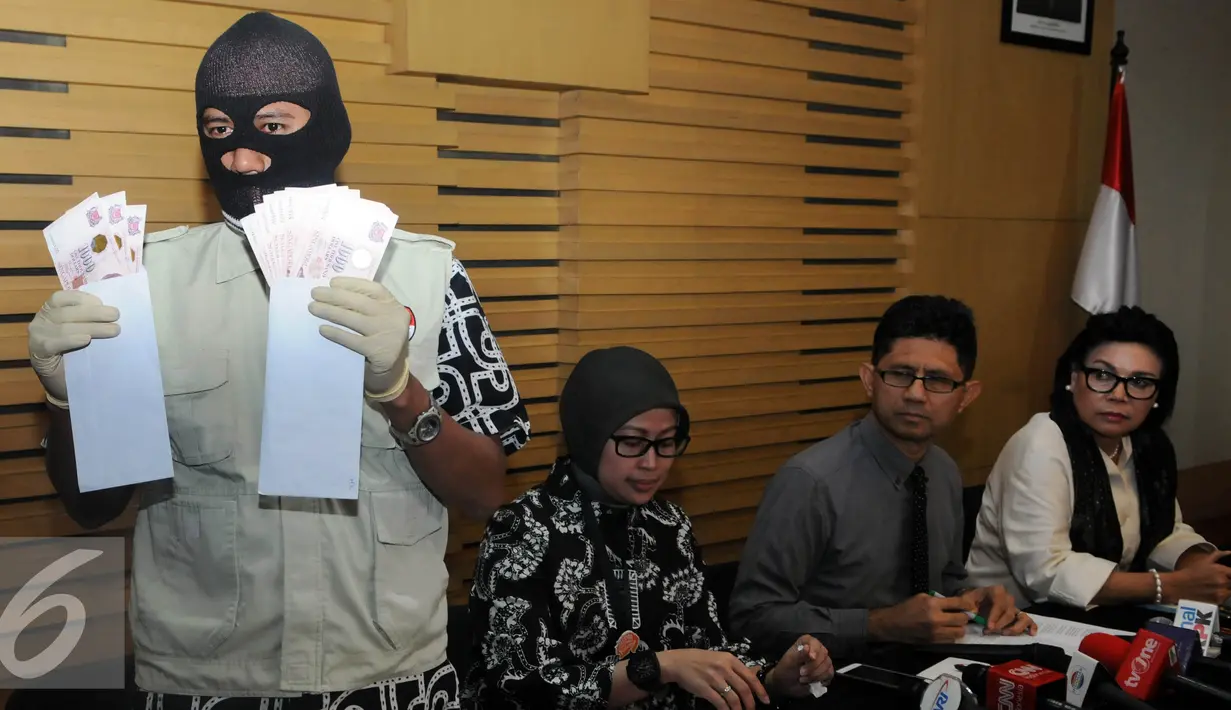 Petugas memperlihatkan barang bukti dalam OTT yang dilakukan KPK terhadap Panitera Pengganti Pengadilan Negeri Jakarta Pusat dengan mengamankan barang bukti uang sebesar 28.000 dolar Singapura, Jakarta, Jumat (1/7). (Liputan6.com/Helmi Afandi)