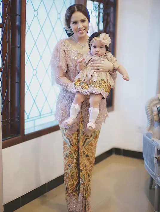 Momo Geisha merupakan salah satu seleb yang kerap mengenakan busana kembar dengan sang anak. Kali ini ia tampil anggun mengenakan kebaya, sedangkan sang anak memakai dress. Meski berbeda model busana, warna pakaian keduanya tampak senada. (Liputan6.com/IG/@therealmomogeisha)