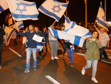 Warga berdemonstrasi menentang gencatan senjata dengan Hamas di Kota Ashkelon Selatan, Israel, Rabu (14/11). PM Israel Benjamin Netanyahu menyetujui gencatan senjata dengan Hamas di Gaza. (JACK GUEZ/AFP)