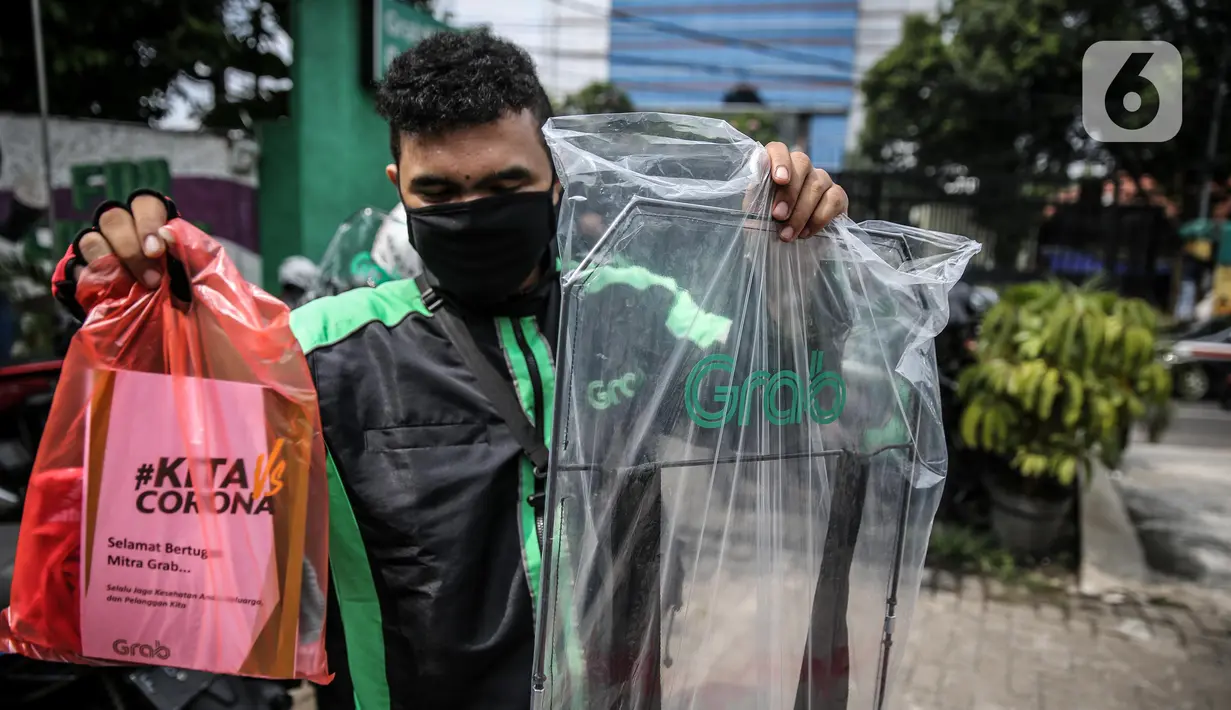 Driver Grab Bike menunjukkan Grab Protect pelindung yang membatasi antara pengemudi dan penumpang saat diluncurkan di Jakarta, Selasa (9/6/2020). Penumpang ojek online (ojol) kini tak perlu khawatir menggunakan transportasi ini di tengah pandemi Corona. (Liputan6.com/Faizal Fanani)