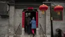 Seorang pria dan wanita berjalan ke halaman rumah mereka di daerah hutong di Beijing (26/2). Hutong-hutong adalah kawasan kejiranan tempat tinggal yang masih membentuk pusat Beijing Lama. (AFP Photo/Nicolas Asfouri)