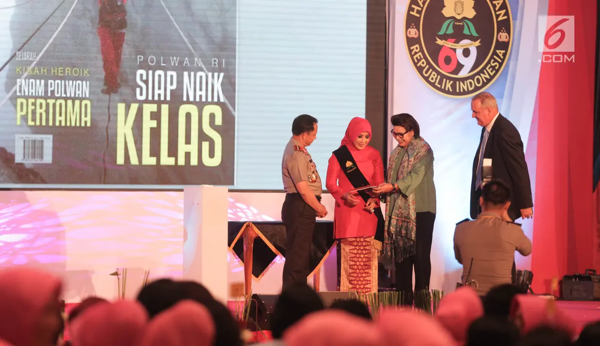 Wakil Ketua KPK Basaria Panjaitan memberikan buku inspirasi kepada  Istri Tri Tito Karnavian dalam acara hari jadi Polisi Wanita (Polwan) yang ke-69 di ruang aula Perguruan Tinggi Ilmu Kepolisian (PTIK), Jakarta, Senin (11/9). (Liputan6.com/Faizal Fanani)