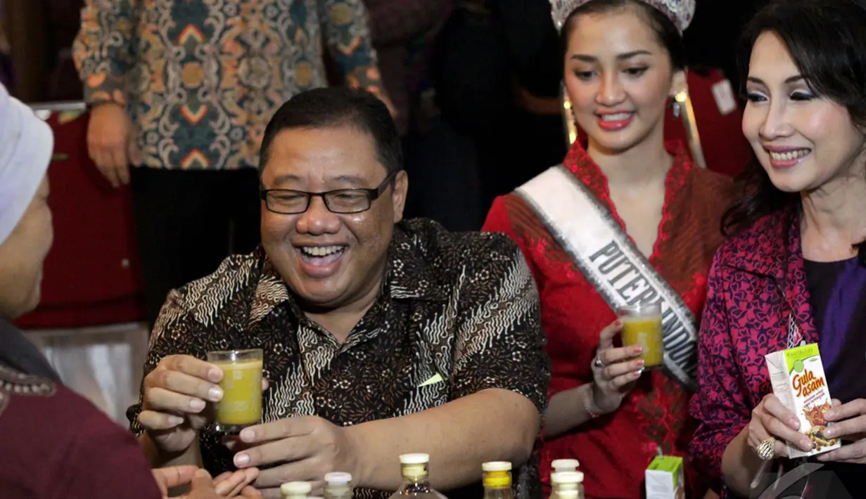 Menteri Koperasi dan UKM AAGN Puspayoga  membudayakan minum jamu karena jamu produk unggulan asli Indonesia meningkatkan ekonomi kerakyatan, Jakarta, Jumat (9/1/2015). (Liputan6.com/Faizal Fanani)