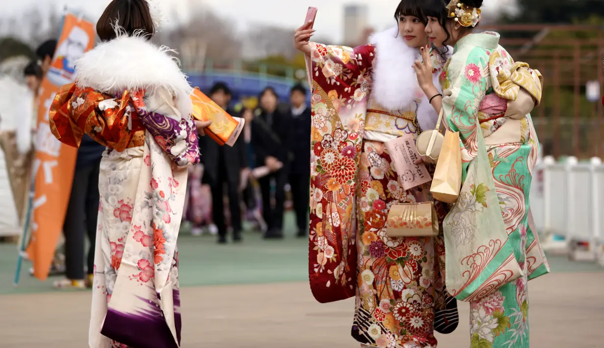 Sejumlah wanita Jepang berpose saat perayaan Coming of Age Day atau Hari Kedewasaan di Toshimaen, Tokyo, Jepang, Senin, (8/1). Hari Kedewasaan biasa diselenggarakan di sebuah hall atau taman karena bisa dihadiri ribuan orang. (AP Photo/Shizuo Kambayashi)