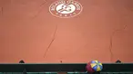 Penonton menggunakan payung menyaksikan lapangan Roland Garros yang ditutup tarpal saat hujan pada turnamen Prancis Terbuka 2016 di Roland Garros, (28/5/2016). (AFP/Philippe Lopez)