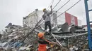 Petugas membenahi kabel listrik menyusul insiden ledakan yang terjadi di outlet Pizza Hut Delivery (PHD) Jatimelati, Bekasi, Minggu (23/10).  Akibat ledakan itu, listrik padam hingga radius 300-500 meter dari lokasi kejadian. (Liputan6.com/Yoppy Renato)